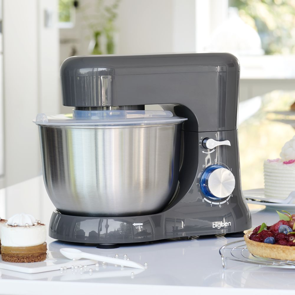 Impastatrice grigia con ciotola e coperchio in acciaio inox. Accanto, una torta e una crostata di frutta.