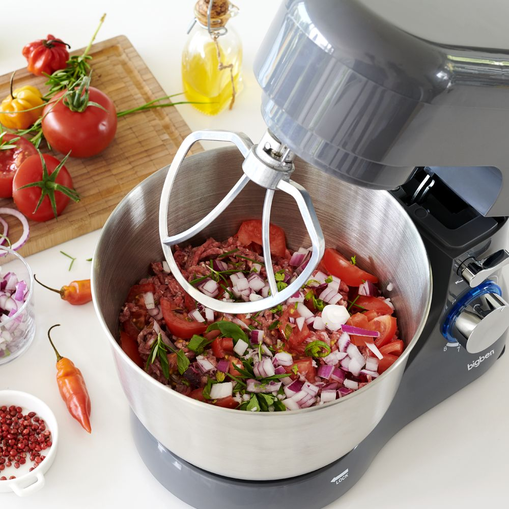 Impastatrice con carne macinata, pomodori e cipolle in ciotola inox.