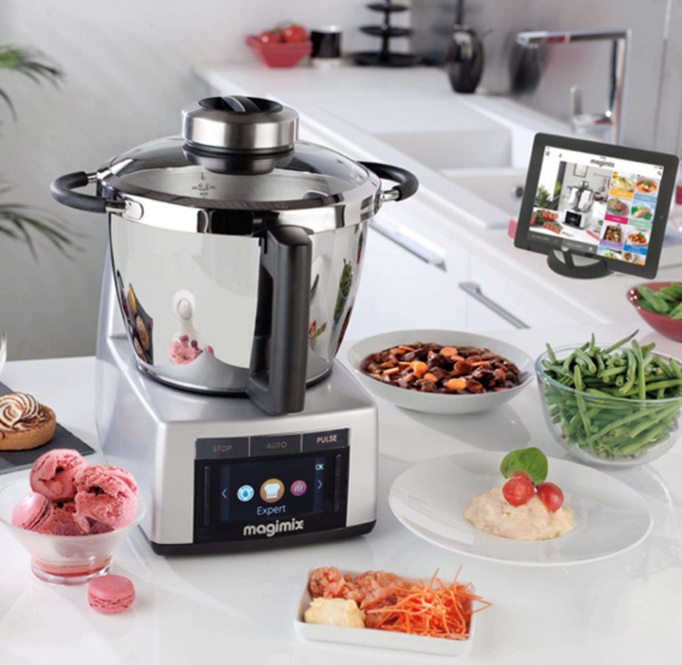 Robot da cucina con ciotola, gelato, macaron, verdure e tablet in cucina.