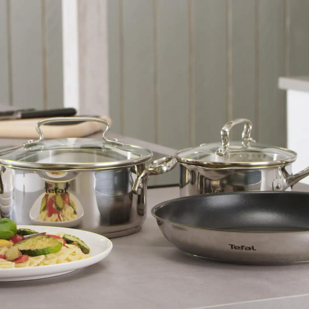 Tefal potten en koekenpan op een aanrecht met pasta en groentegerecht.