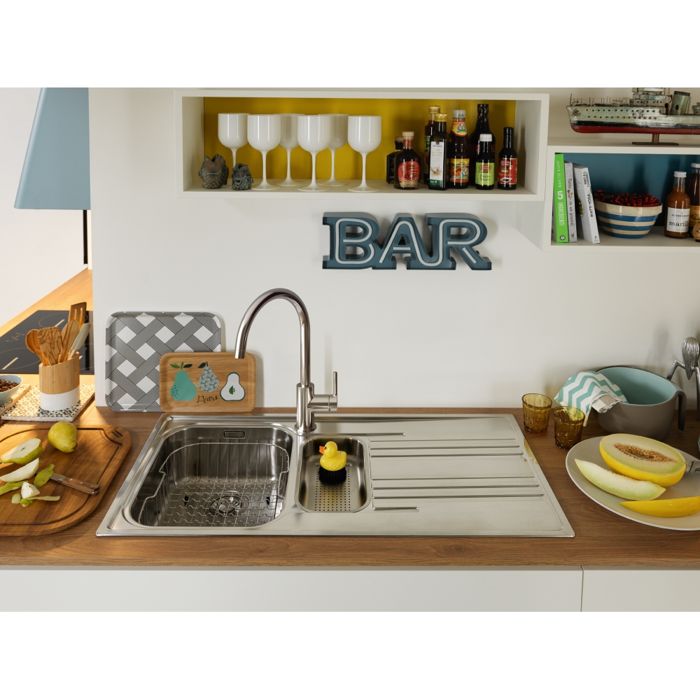 Eine Küche mit Spüle, Obst und Dekorationsartikeln wie dem Wort 'BAR'.