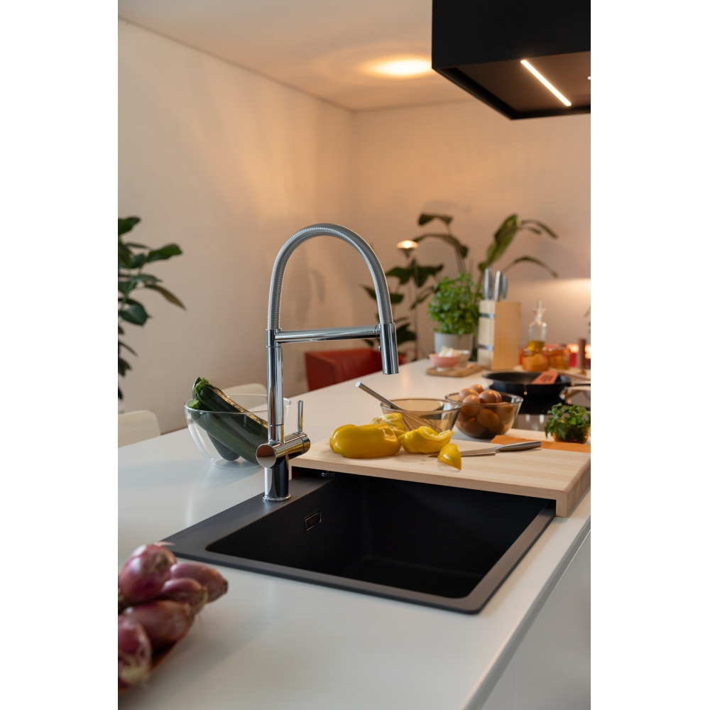 Modern bir mutfakta lavabo, musluk, sebzeler ve yumurtalar tezgah üzerinde.