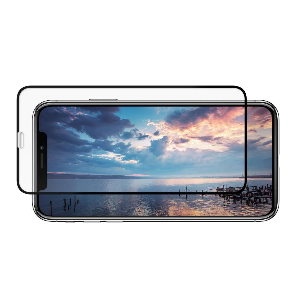 Uno smartphone con protezione schermo mostra un paesaggio marino con un molo al tramonto.