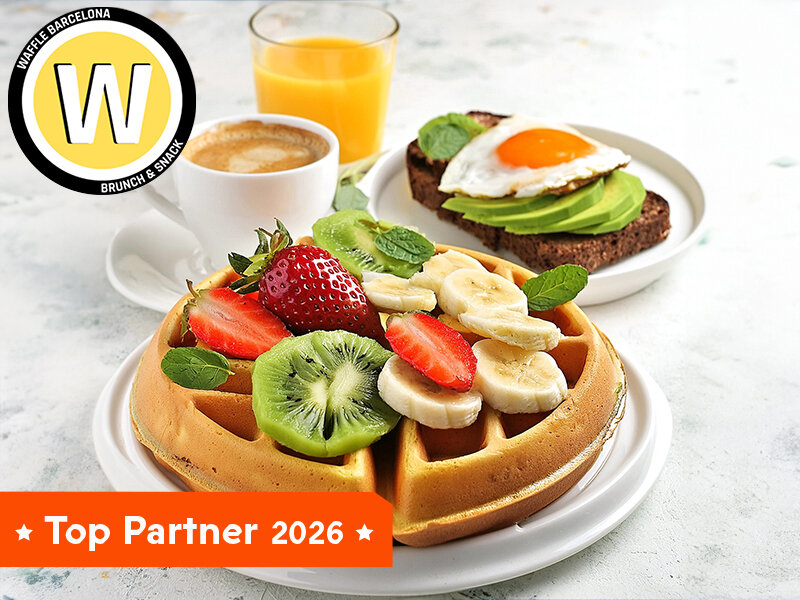 Un gofre con fruta, café y zumo. Tostada con huevo y aguacate al lado.