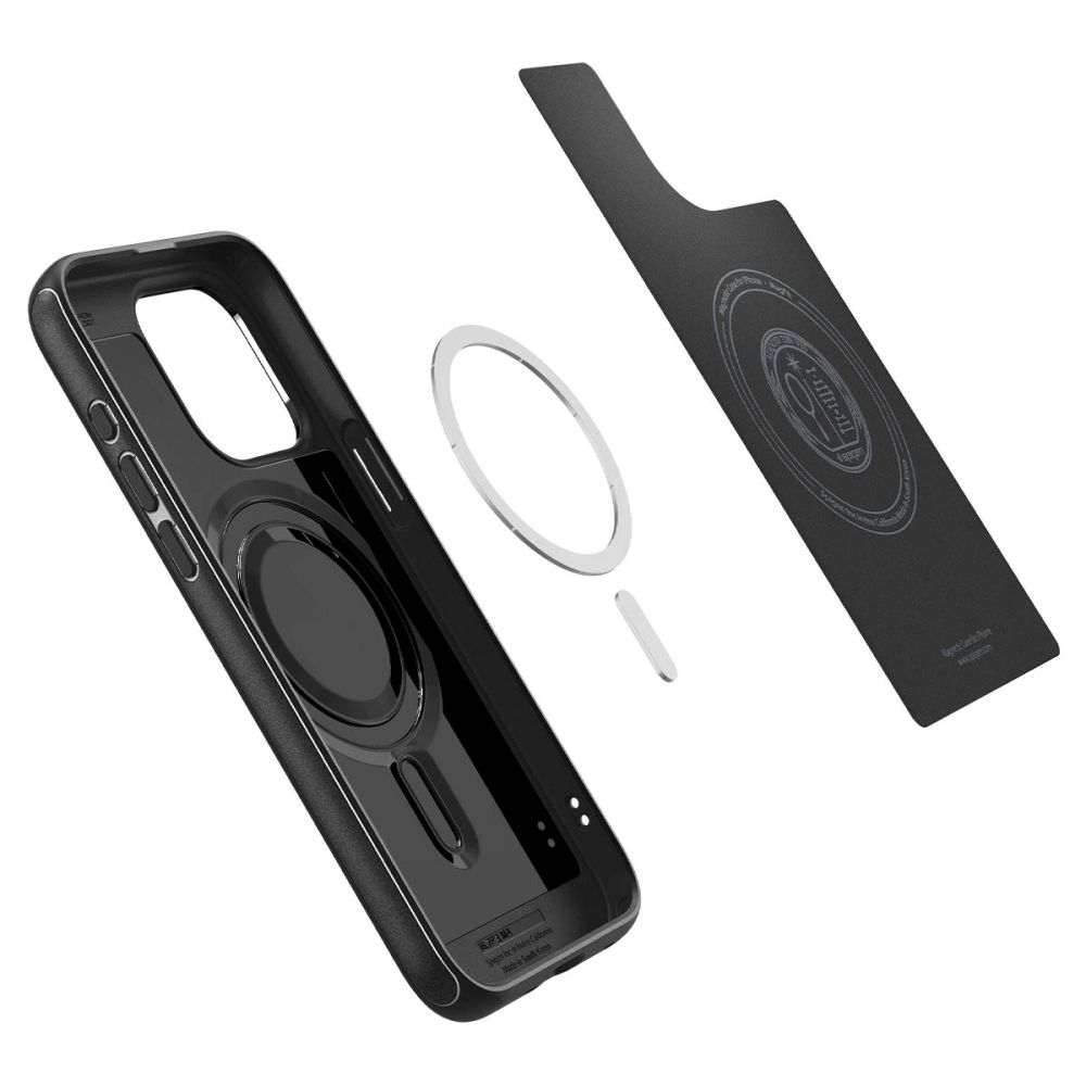 Custodia nera per telefono con anello magnetico e piastra metallica su sfondo bianco.