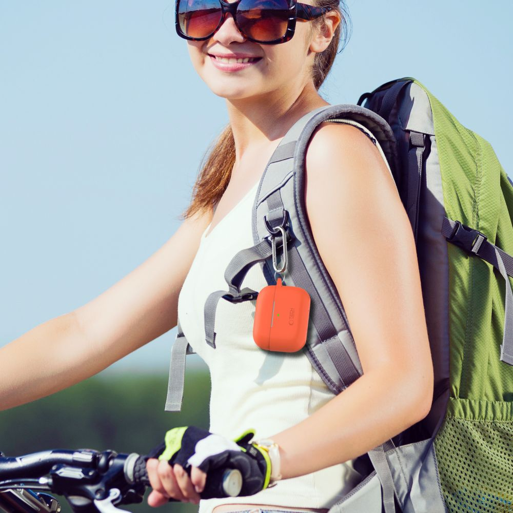 A woman on a bicycle wearing a backpack, an orange case hangs from a strap.