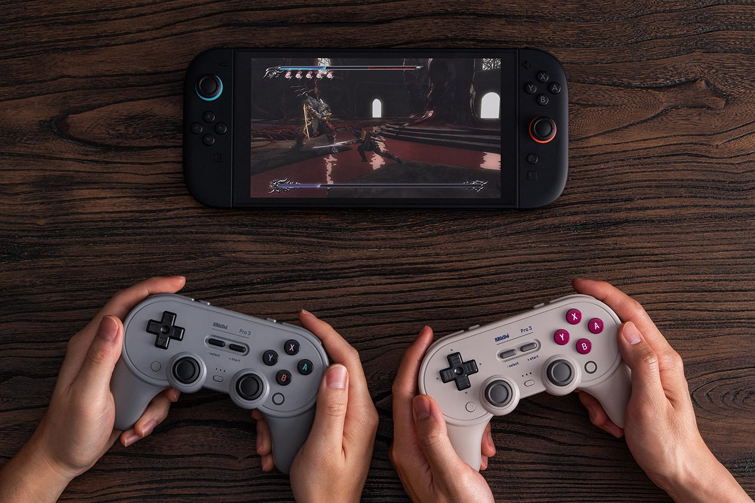 Dwie ręce trzymają kontrolery przed konsolą Nintendo Switch wyświetlającą grę walki.