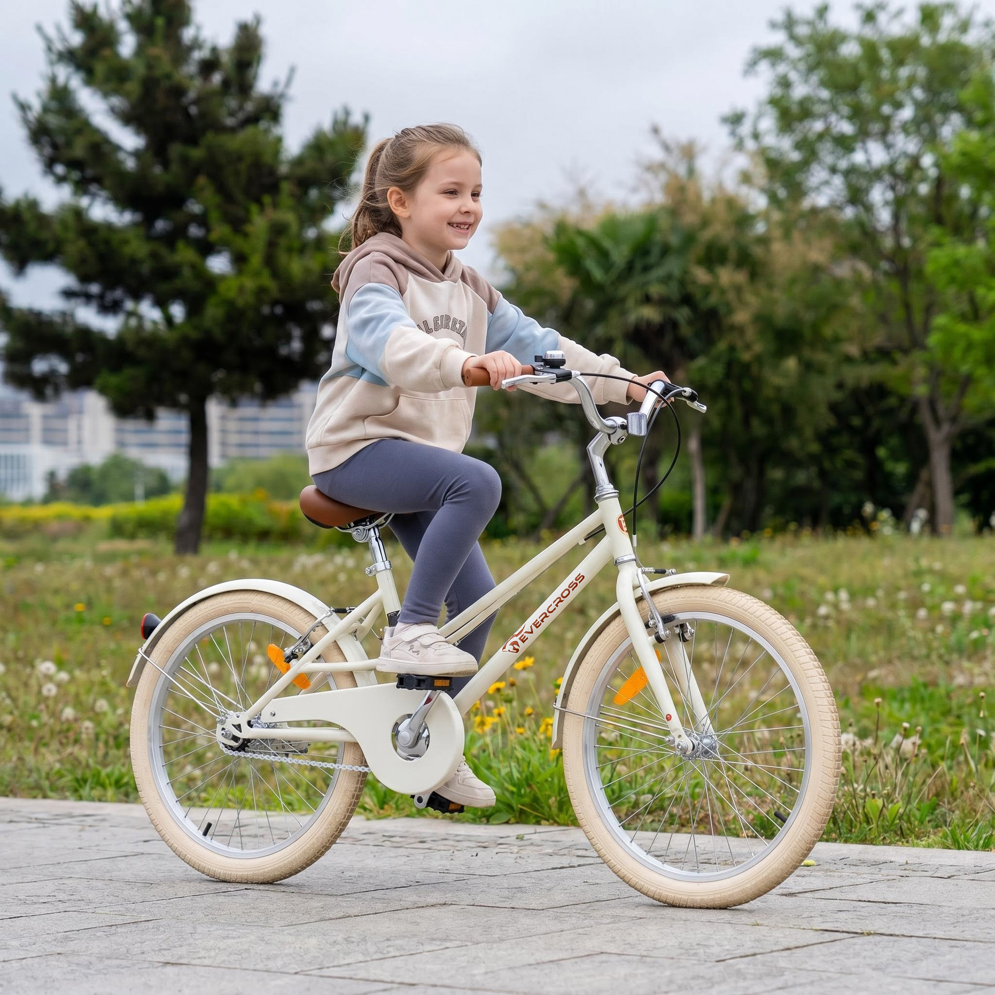 Ein Mädchen fährt ein beiges Fahrrad auf einem Weg im Park. Bäume und Gras im Hintergrund.