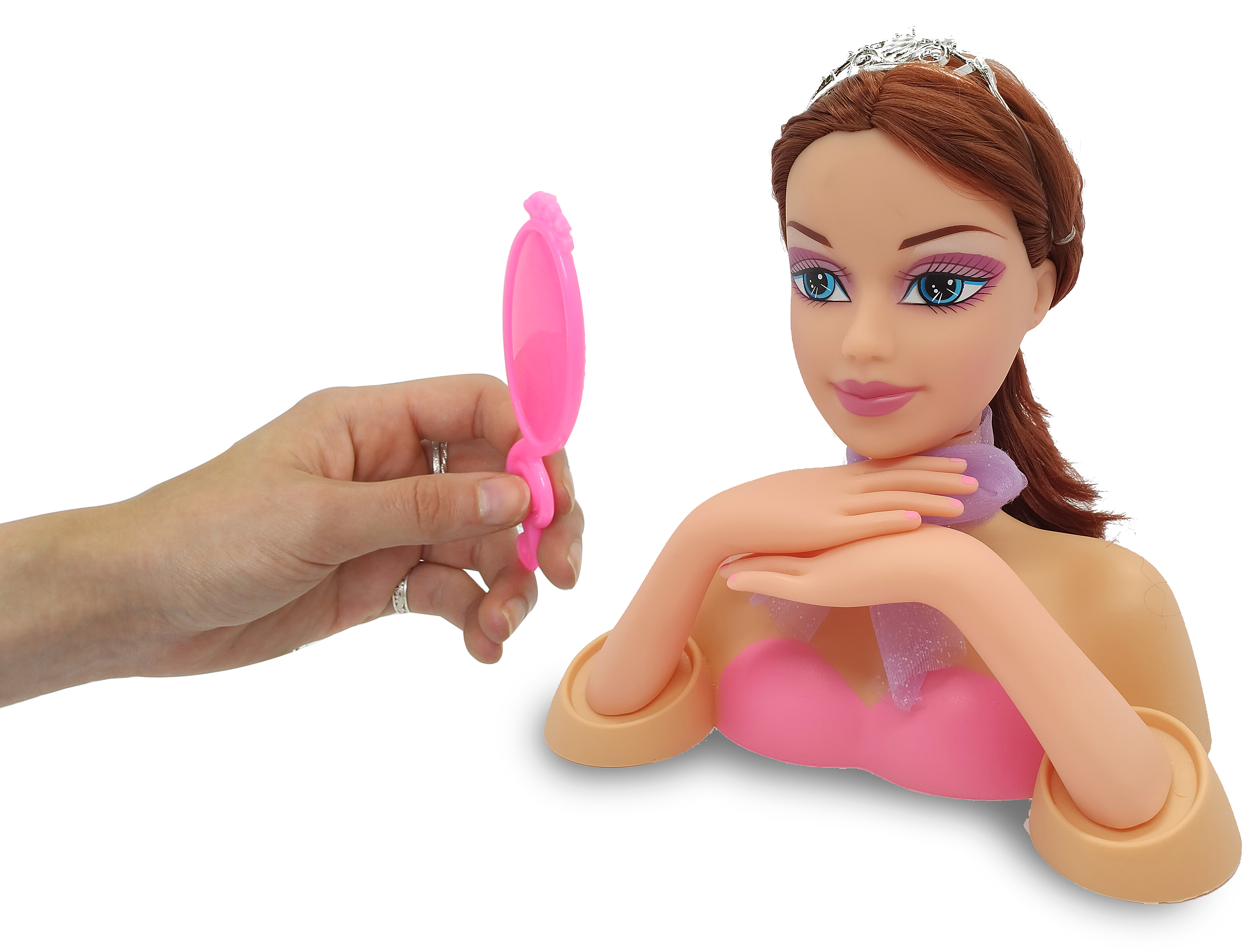 Eine Hand hält einen rosa Spiegel vor eine Puppe mit Diadem und lila Schal.