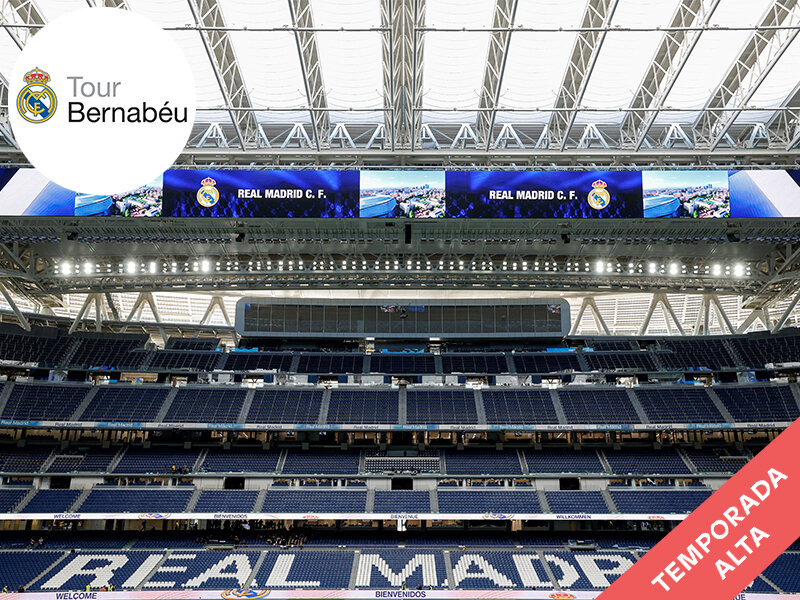 Estadio Bernabéu vacío con asientos azules, pantallas y estructura de techo.