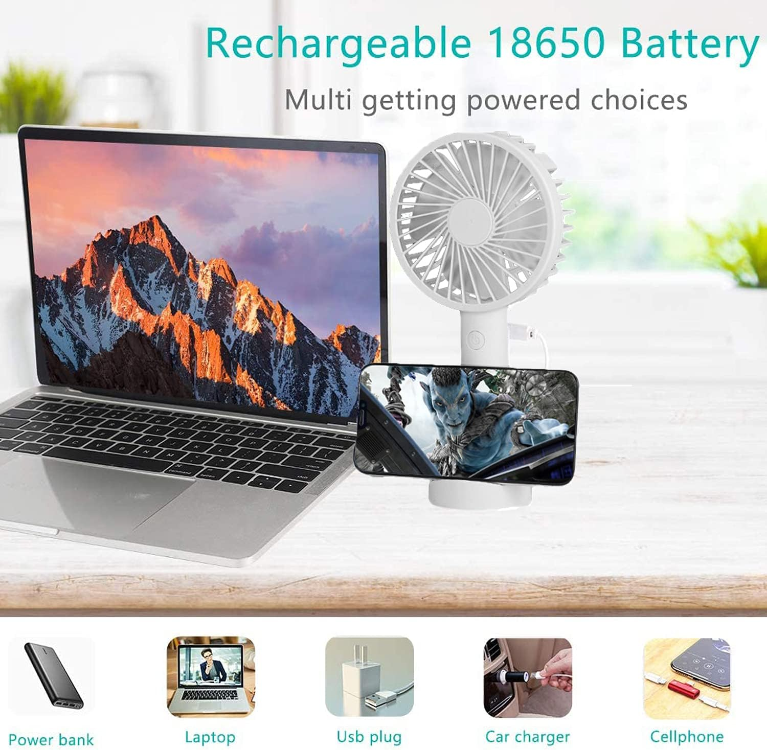 Ein Laptop, ein Ventilator und ein Handy werden auf einem Tisch gezeigt.