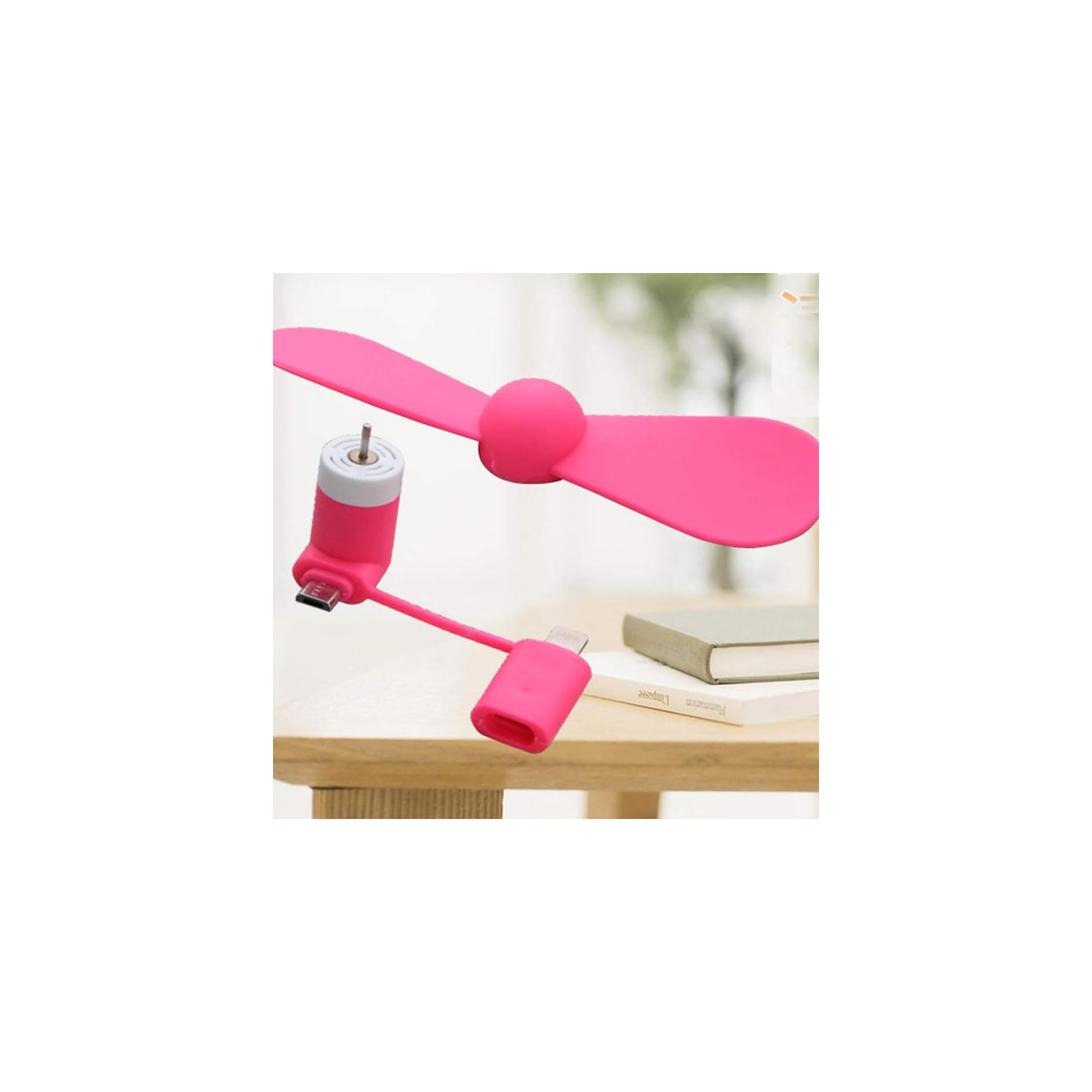 Ein kleiner rosa Propellerlüfter mit USB- und Lightning-Anschlüssen auf einem Holztisch.