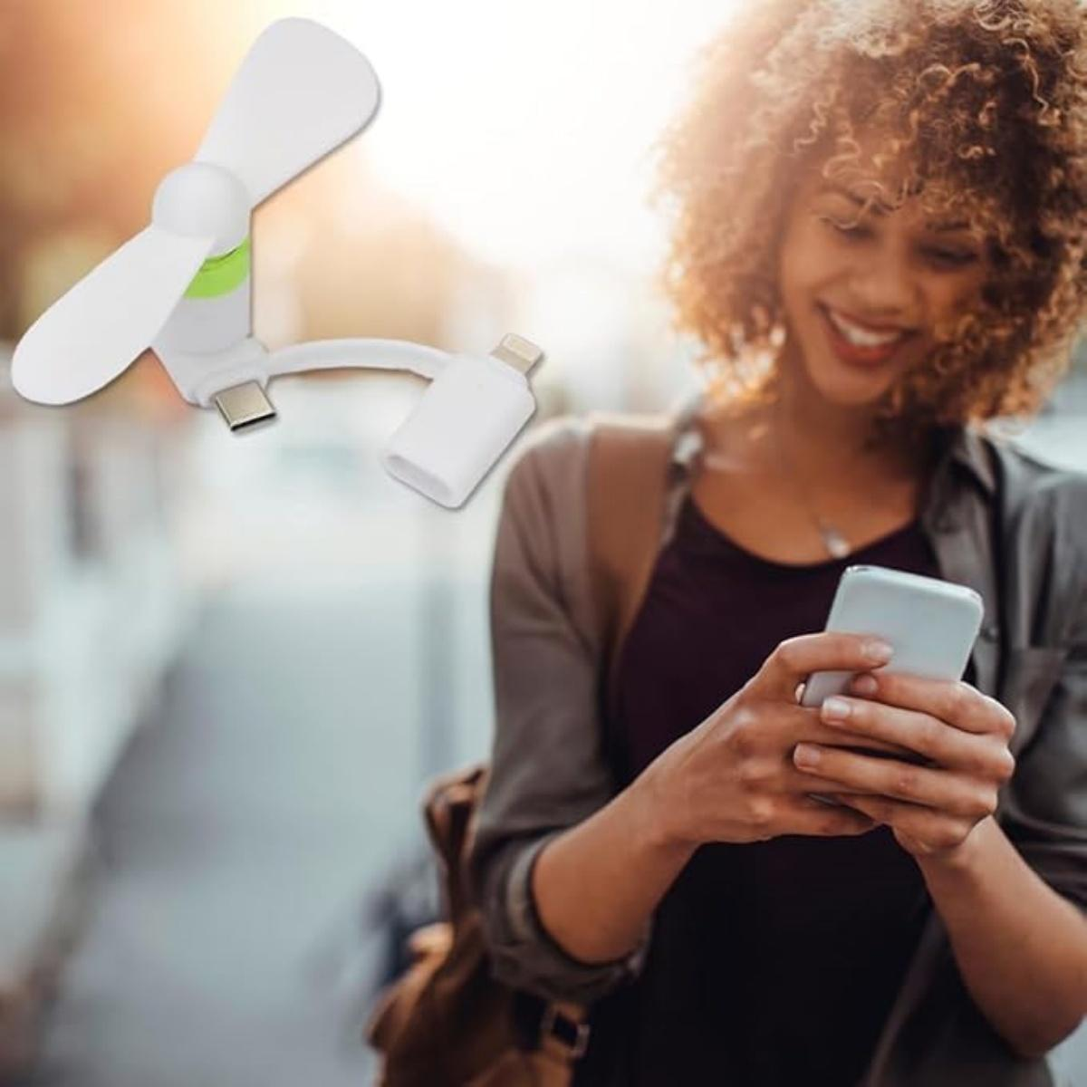 Ein weißer Mini-USB-Ventilator mit einem Handy und einer Frau, die ein Handy benutzt.