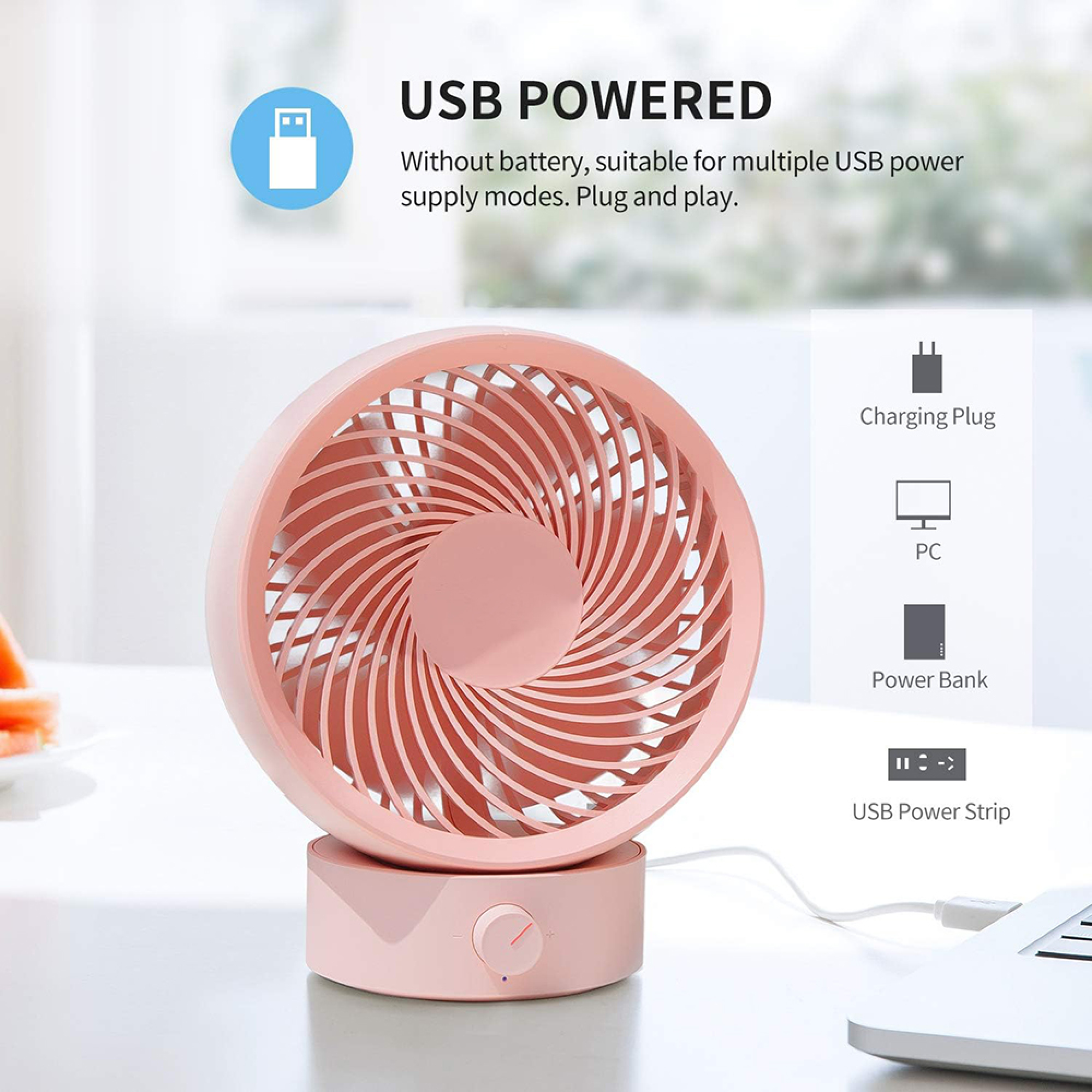 Ein rosafarbener USB-Ventilator steht auf einem Tisch neben einem Laptop.