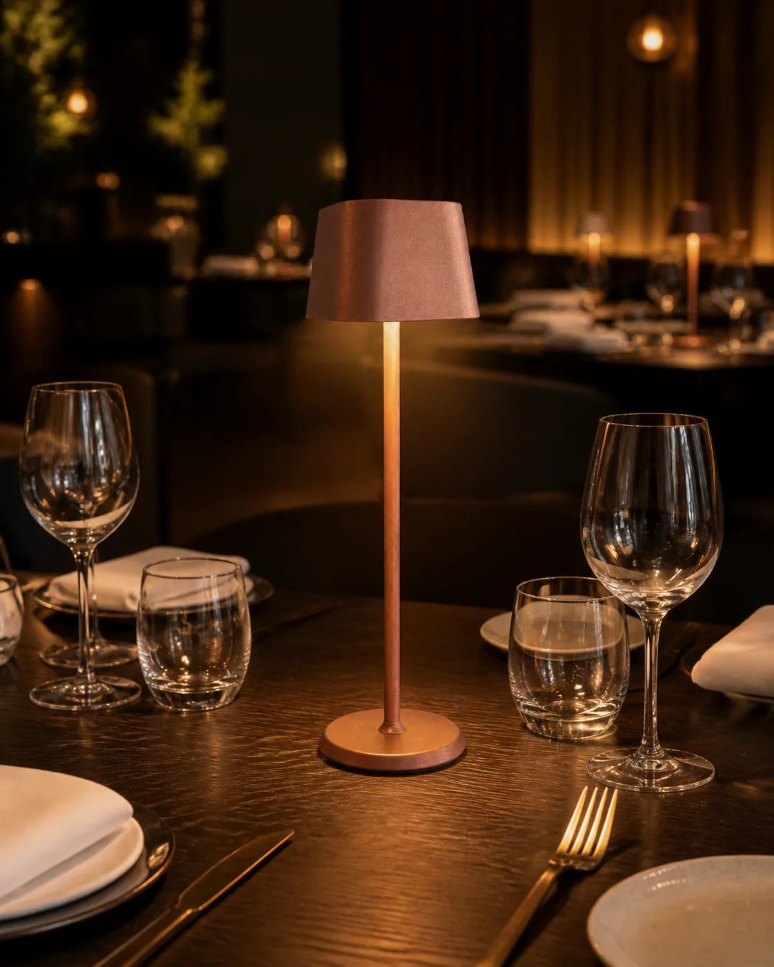 Ein Tisch ist mit Gläsern, Servietten und einer Lampe gedeckt.