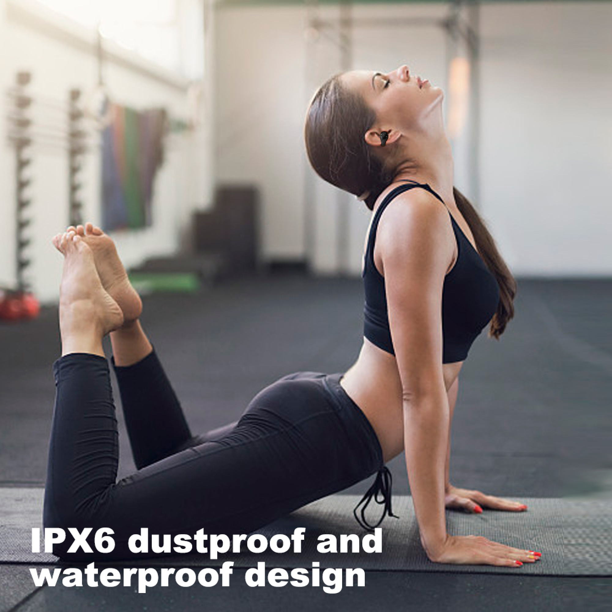 Frau in Yoga-Pose auf Matte in Turnhalle, trägt Kopfhörer.