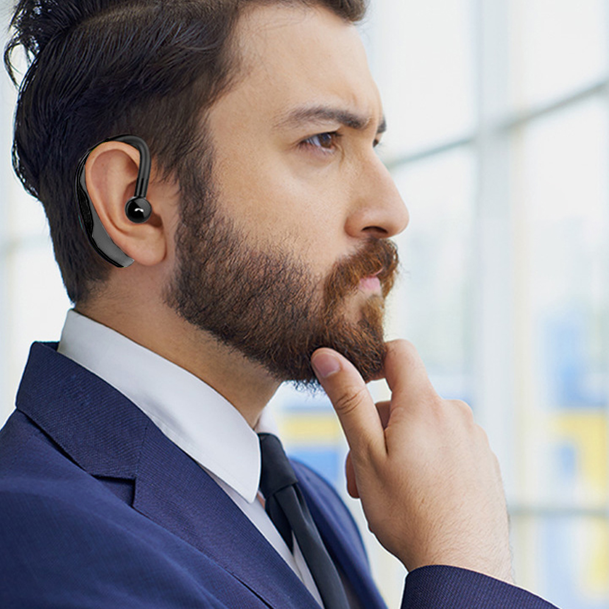 Mann mit Bart trägt einen blauen Anzug und ein Headset.