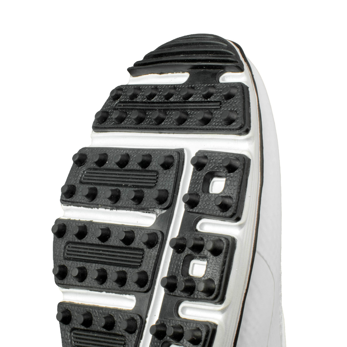 Nahaufnahme der weißen Schuhsohle mit schwarzen Noppen für Traktion.