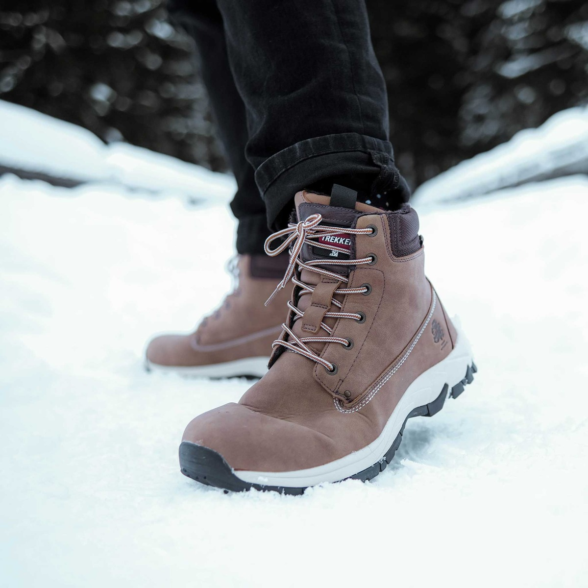 Braune Winterstiefel mit Schnürsenkeln auf Schnee.