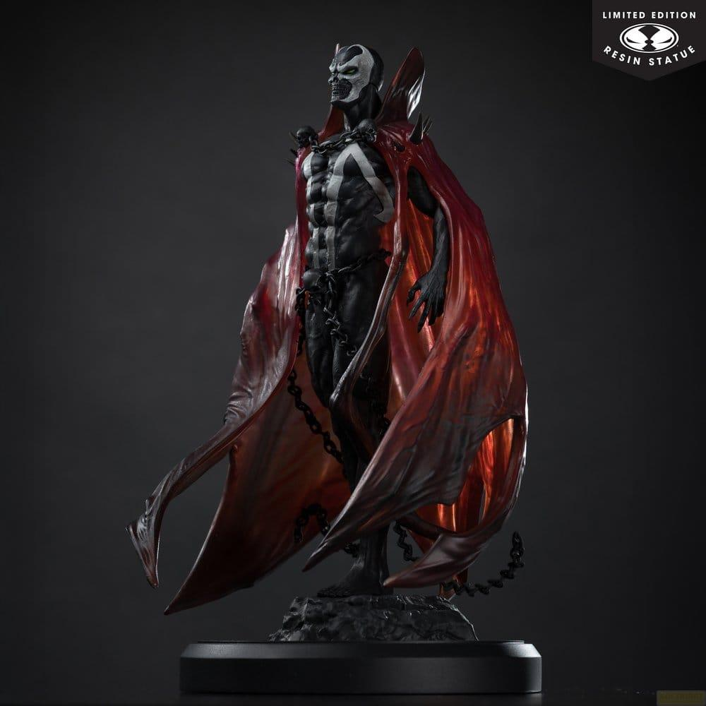 Una statua di Spawn con mantello rosso e catene su sfondo scuro.