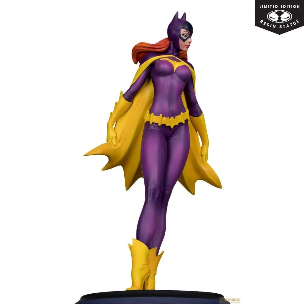 Statua di Batgirl in costume viola e giallo, in piedi eroicamente su sfondo bianco.