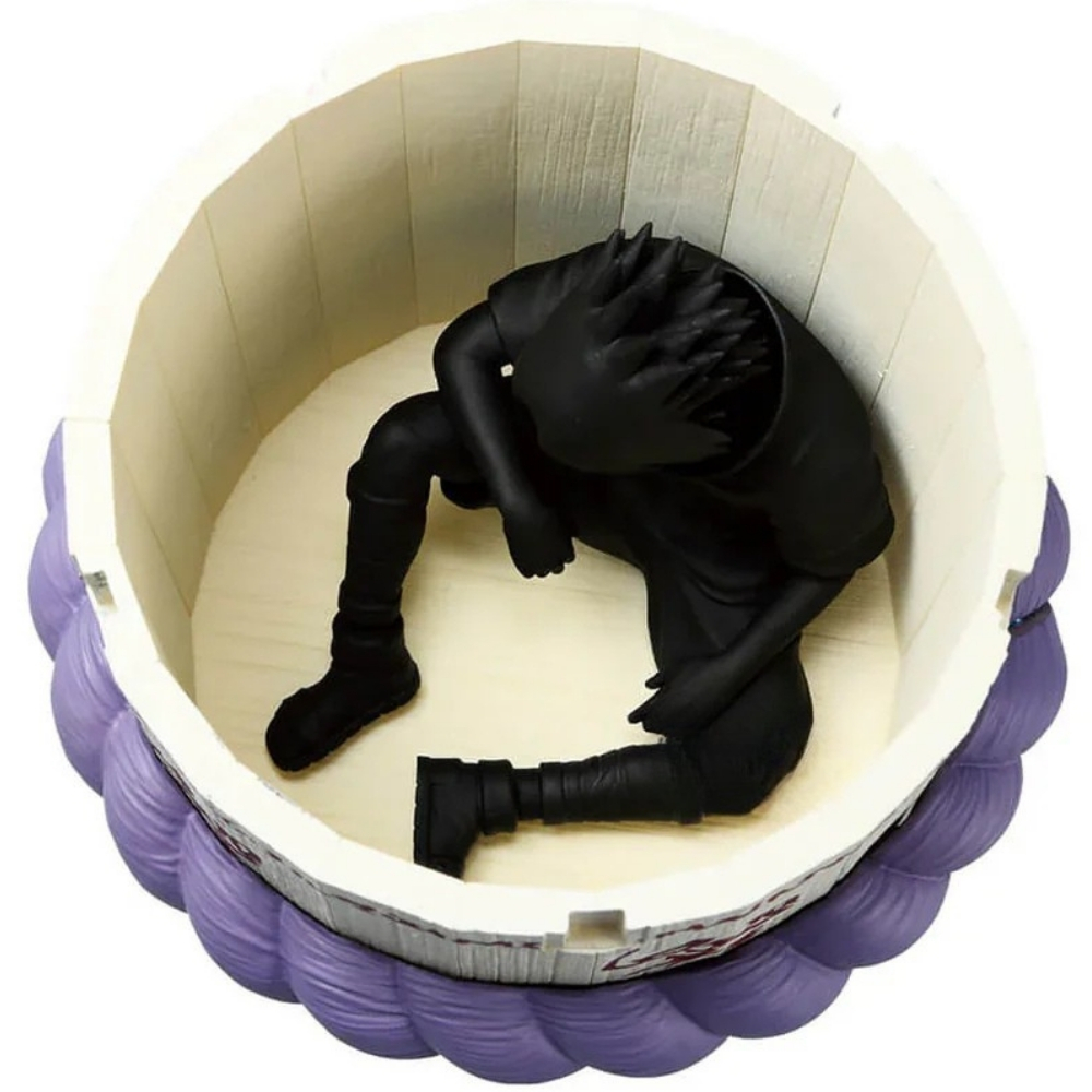 Una figura nera in posa accovacciata siede all'interno di un contenitore cilindrico bianco e viola.
