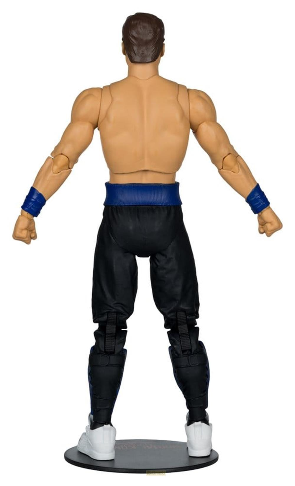 Un action figure maschile con capelli castani, pantaloni blu, polsini blu e scarpe bianche sta su una base.