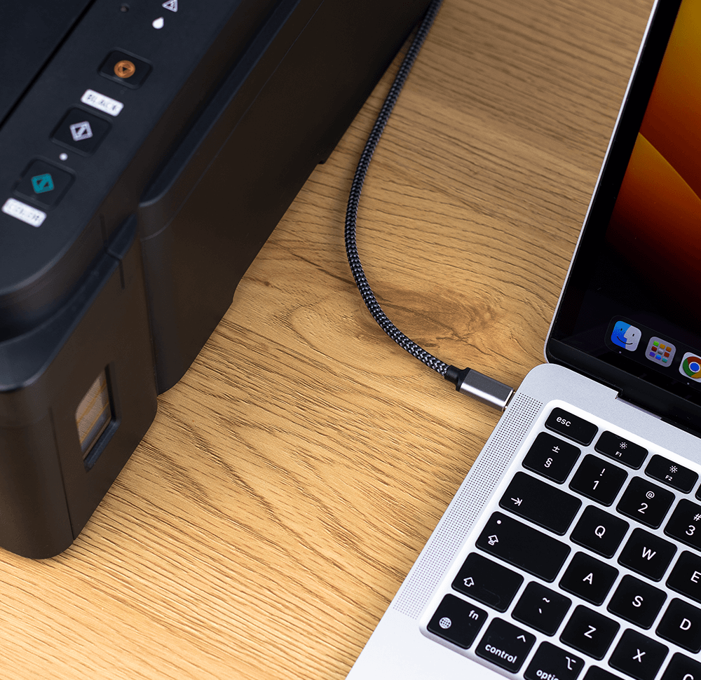 Ein Drucker ist über ein USB-Kabel mit einem Laptop verbunden.