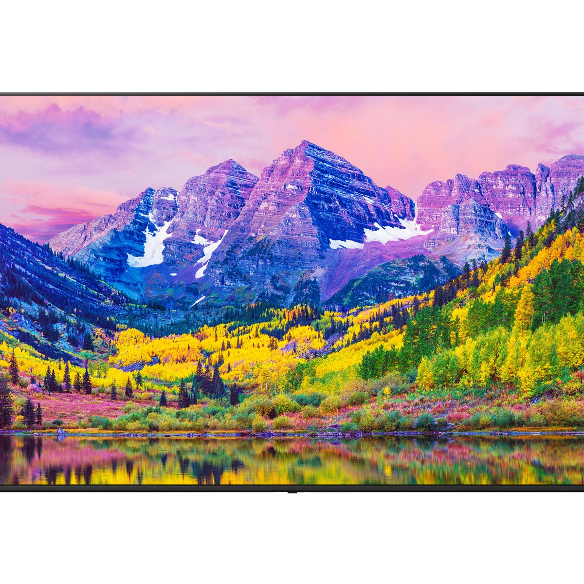 Panorama montano con alberi autunnali colorati e lago riflesso al tramonto.