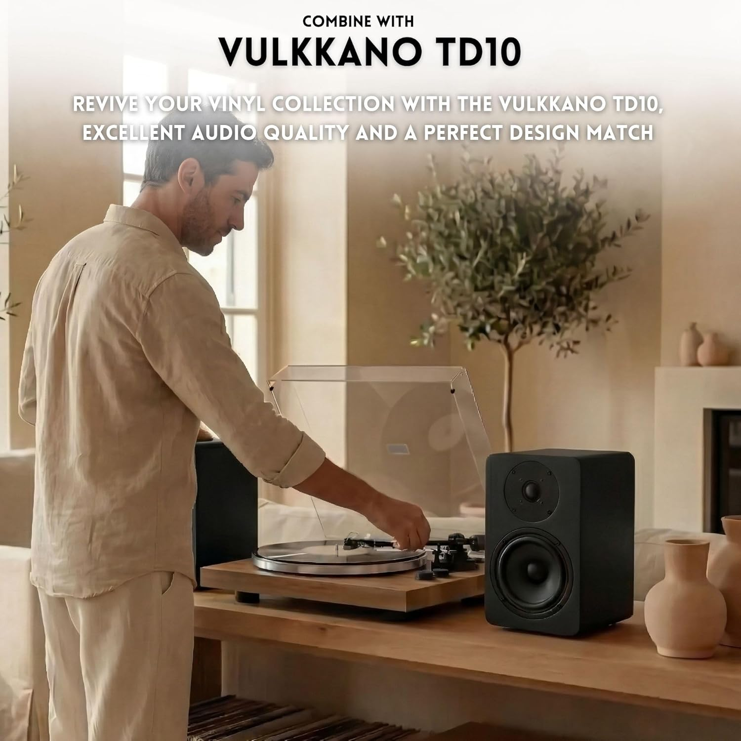 Hombre operando tocadiscos con altavoz Vulkkano TD10 en sala elegante.