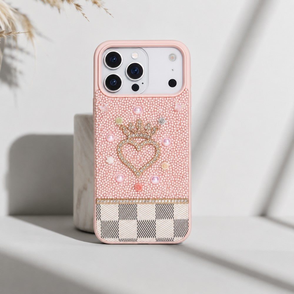 Kalp, taç ve incilerle süslenmiş pembe telefon kılıfı.