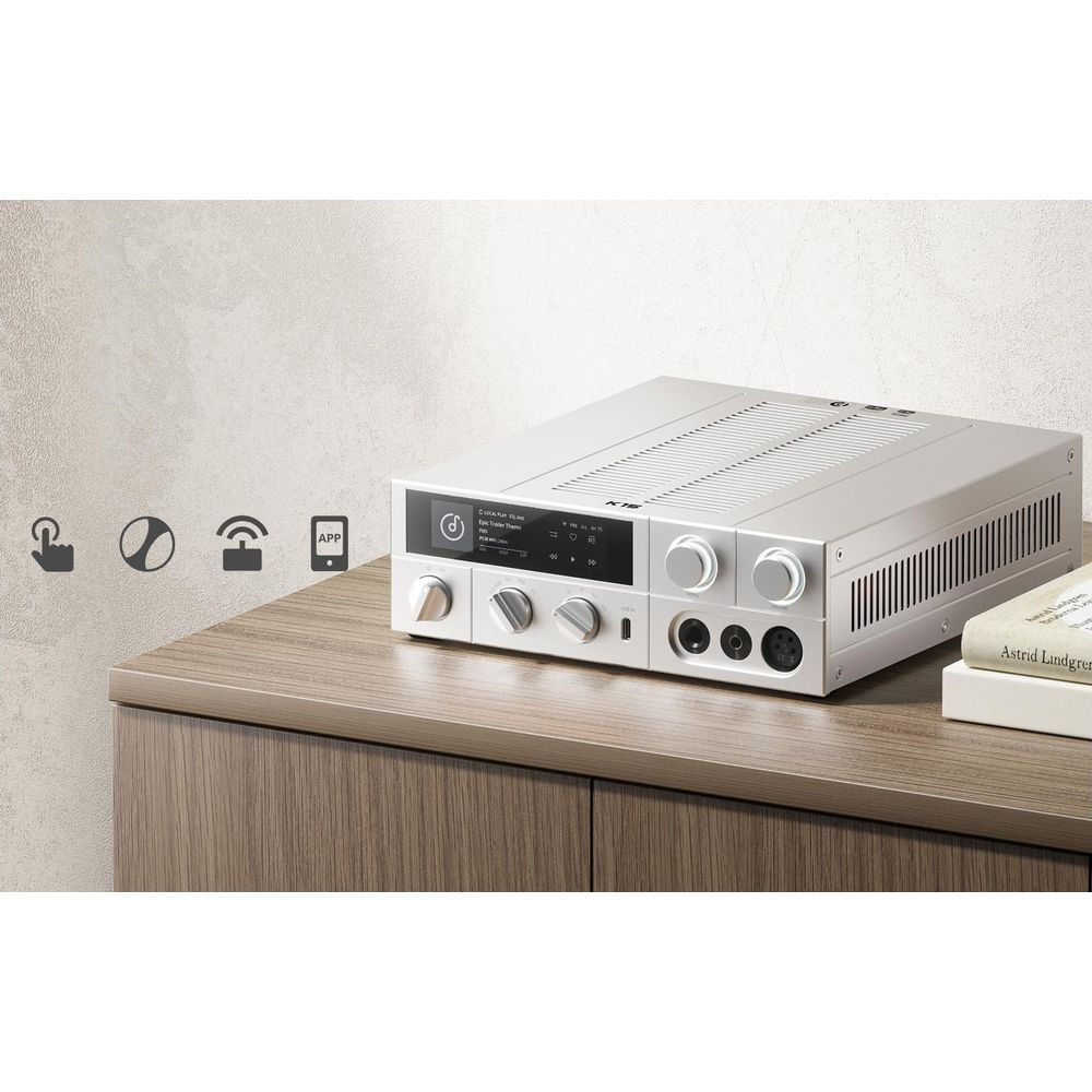 Srebrne urządzenie audio na drewnianych meblach z ikonami i książkami.