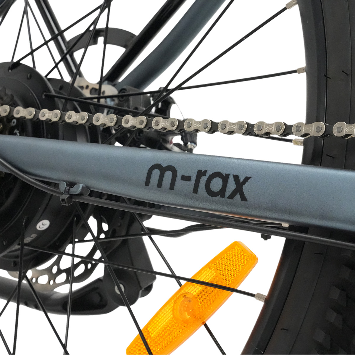 Nahaufnahme der Fahrradkette, des Rahmens mit Logo und eines orangefarbenen Reflektors.