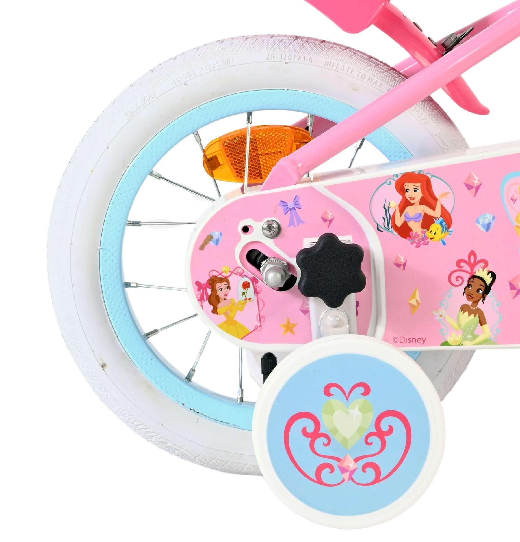 Ein rosafarbenes Kinderfahrrad mit Disney-Prinzessinnen-Motiven und Stützrädern.