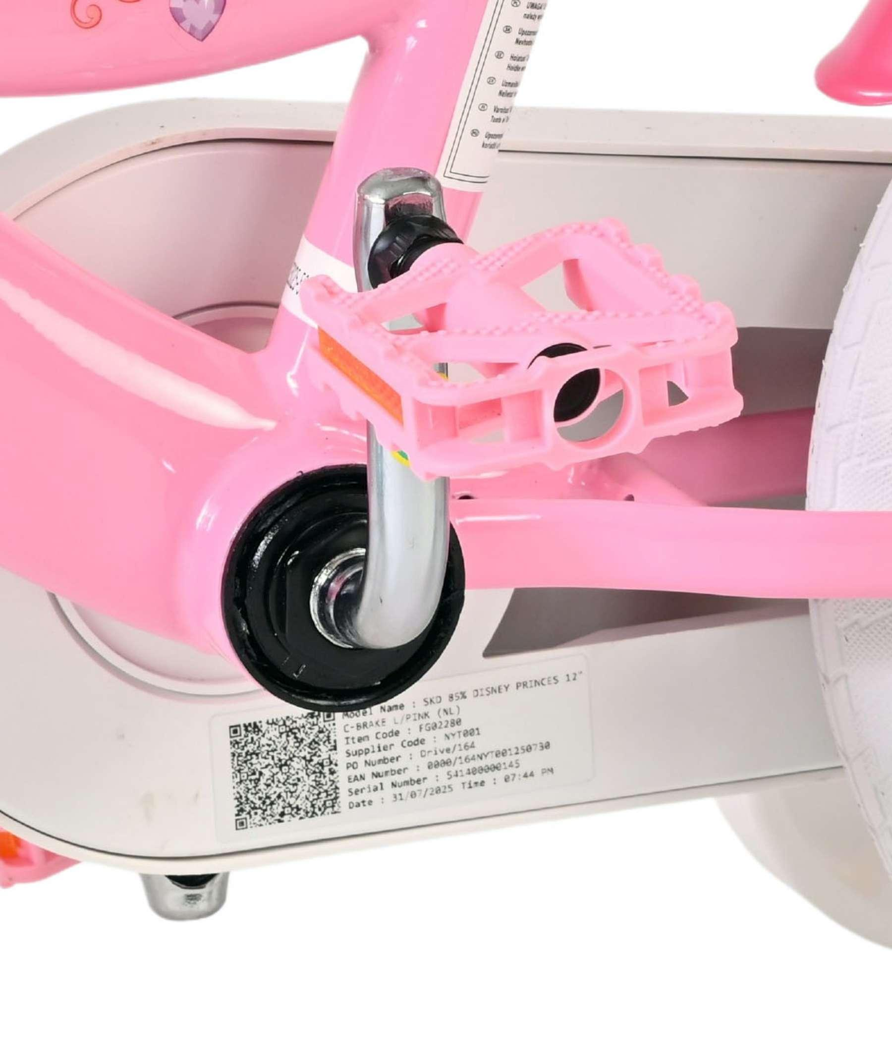 Nahaufnahme eines rosa Fahrradpedals mit silbernen Kurbeln und einem Aufkleber.