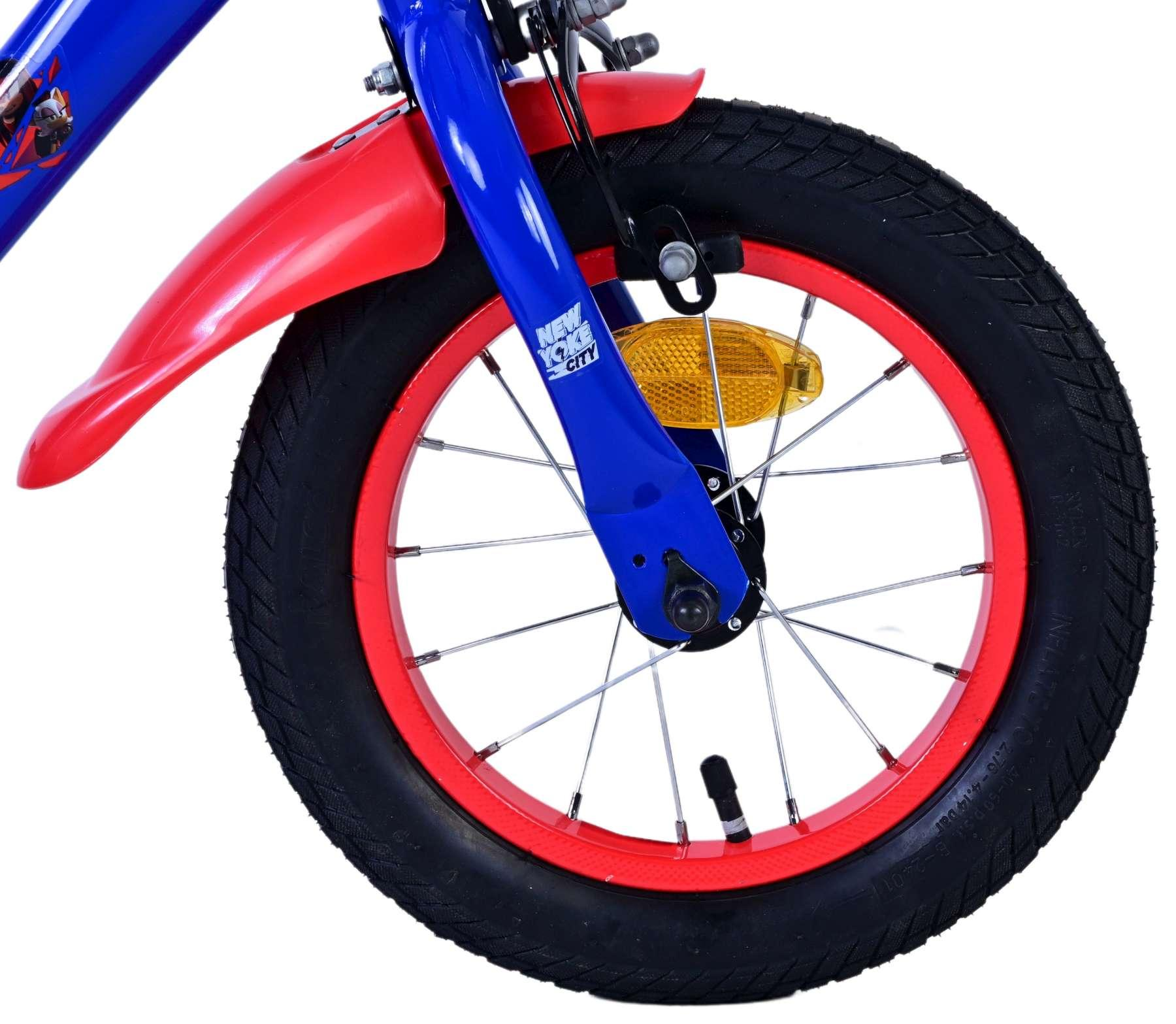 Vorderreifen eines blauen und roten Kinderfahrrads mit Reflektor.