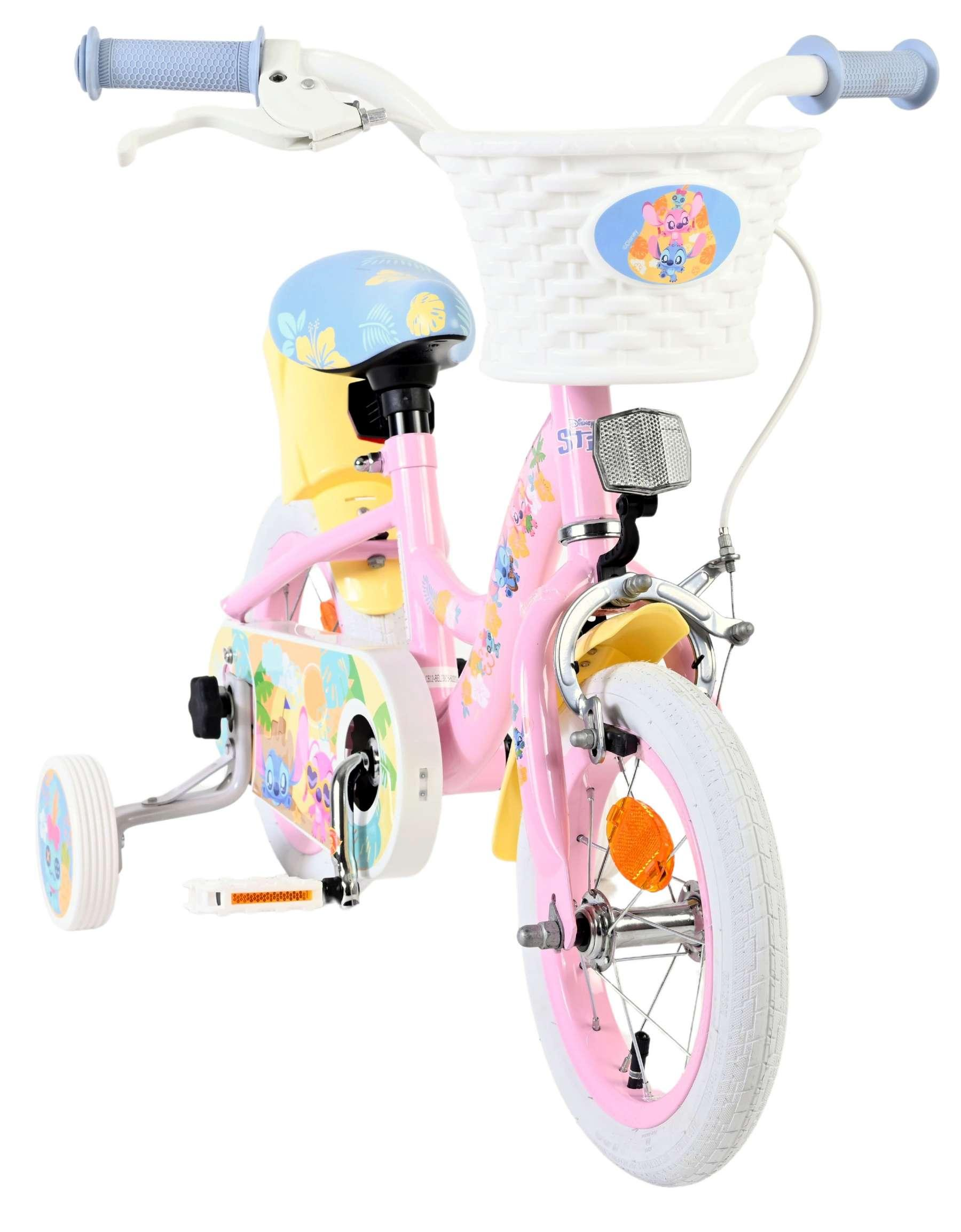 Ein rosafarbenes Kinderfahrrad mit Stützrädern, einem weißen Korb und Disney-Motiven.