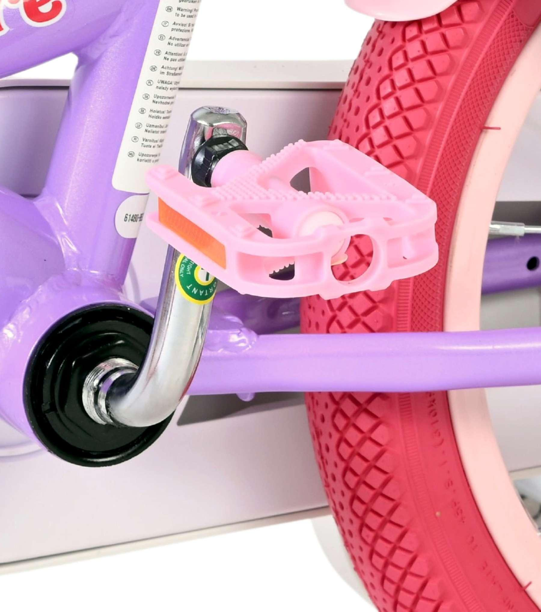 Nahaufnahme des rosa Pedals und des roten Fahrradreifens auf einem lila Rahmen.