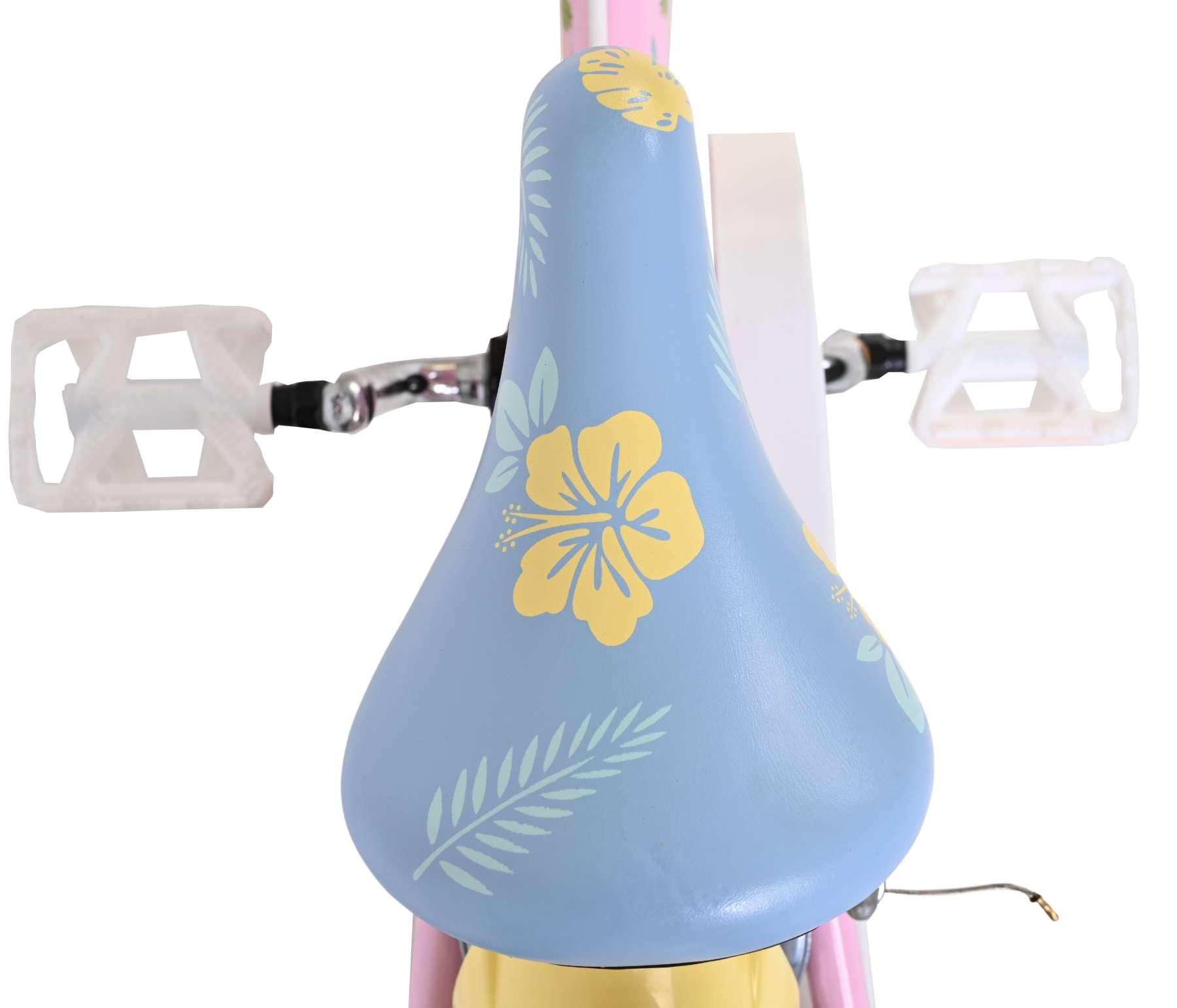 Hellblaues Fahrradsattel mit gelben Blumen und grünen Blättern, weiße Pedale.