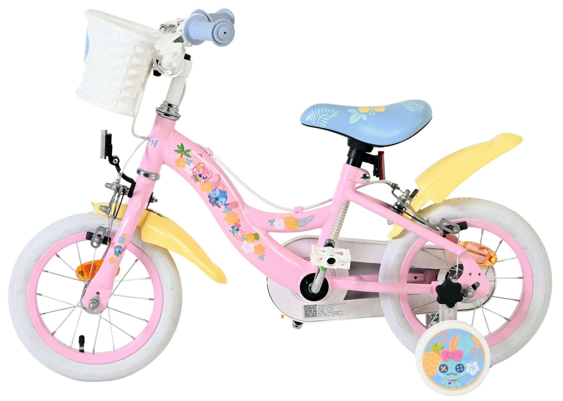 Ein pinkes Kinderfahrrad mit weißen Reifen, einem hellblauen Sattel und gelben Schutzblechen. Es hat einen weißen Korb und Stitch-Aufkleber.
