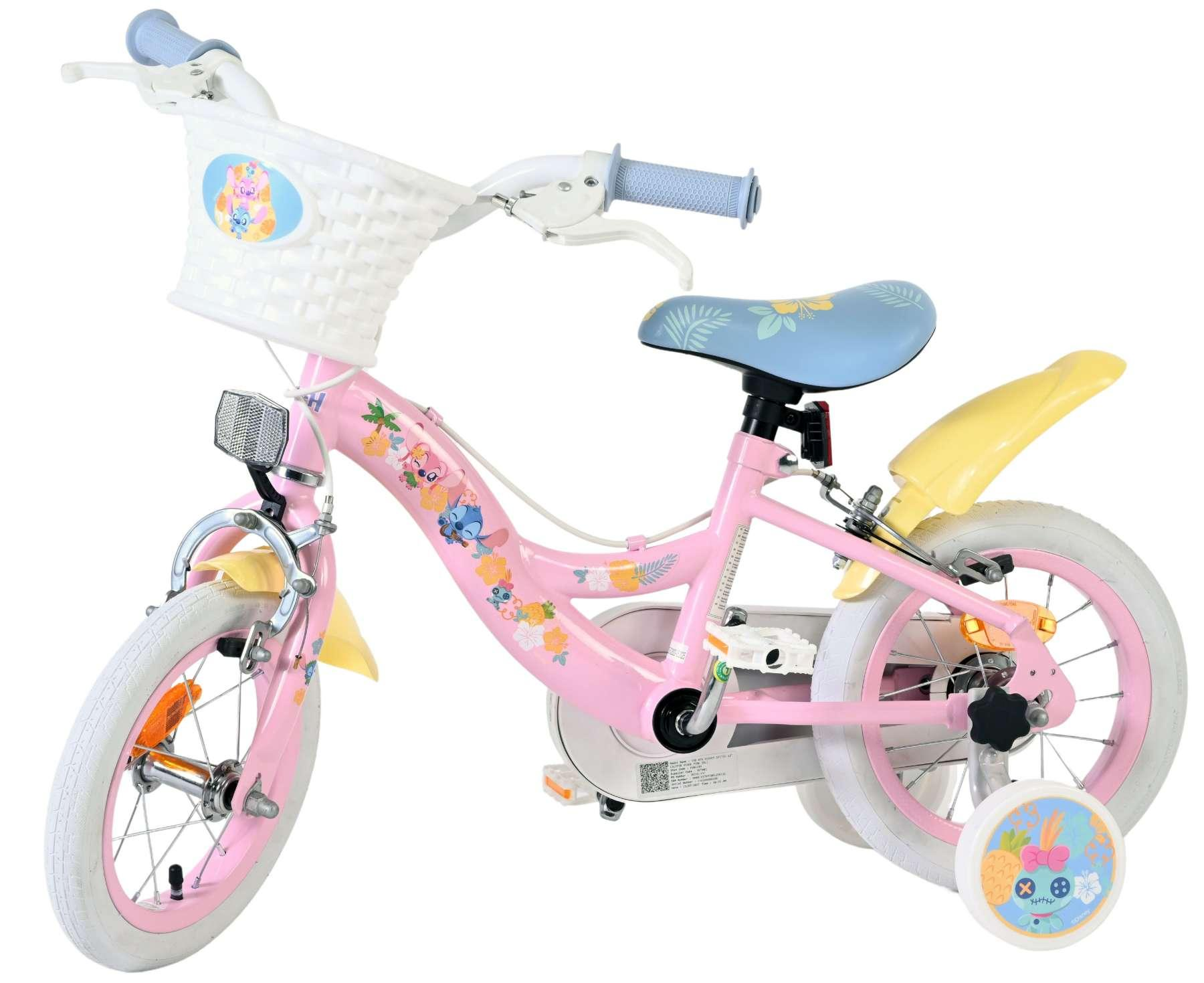 Ein rosafarbenes Kinderfahrrad mit weißen Reifen, einem weißen Korb und Stützrädern.