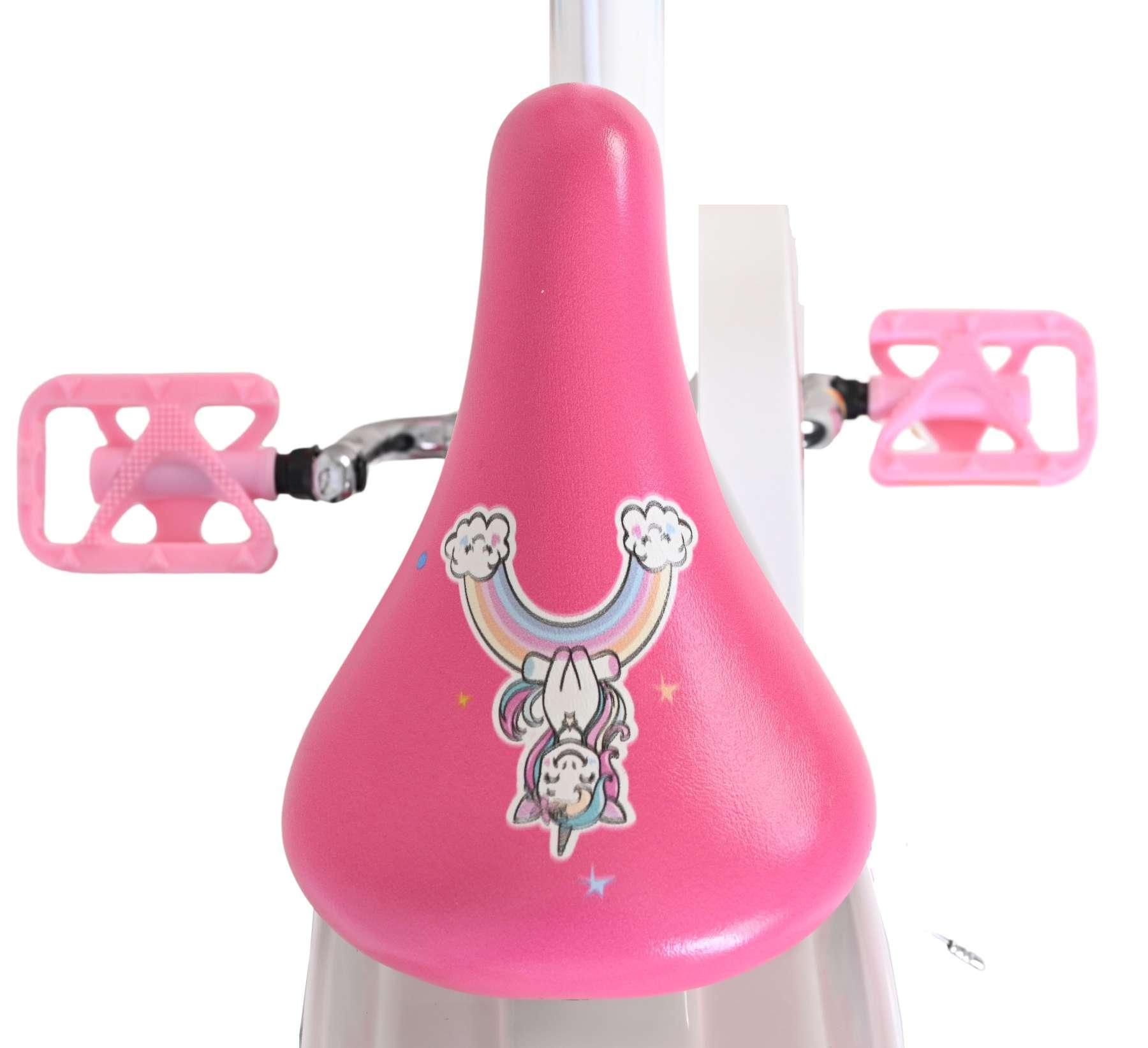 Ein pinker Fahrradsitz mit einem Einhorn-Regenbogen-Aufkleber und pinken Pedalen.