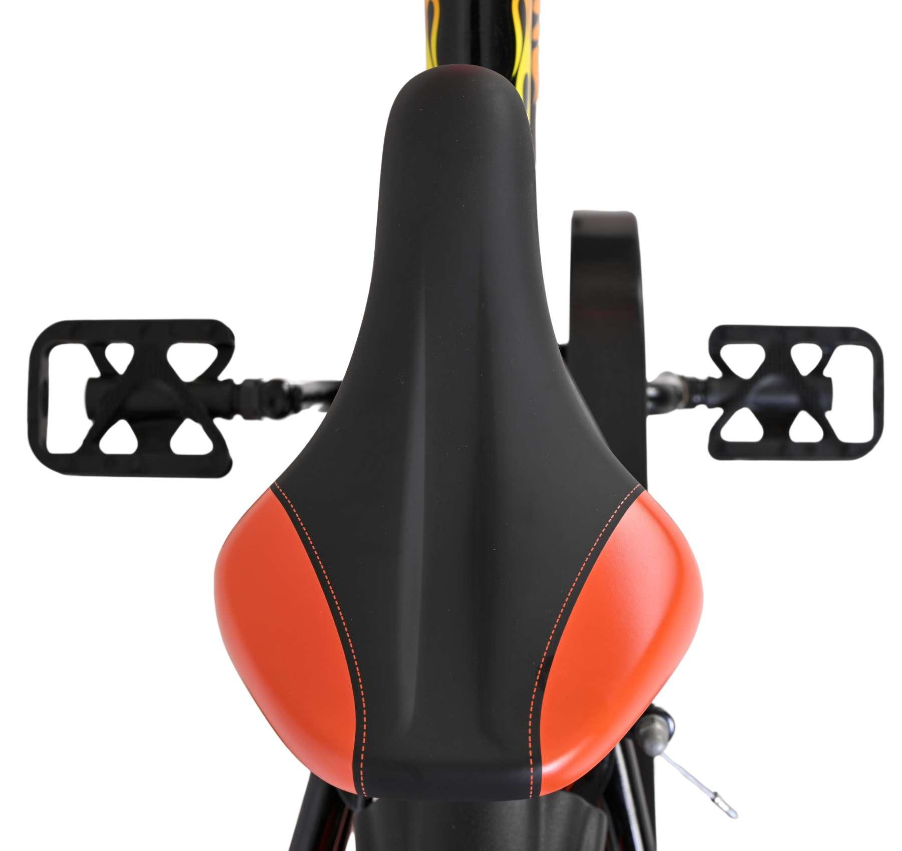 Nahaufnahme eines Fahrradsattels mit orangefarbenen Seiten und schwarzen Pedalen.