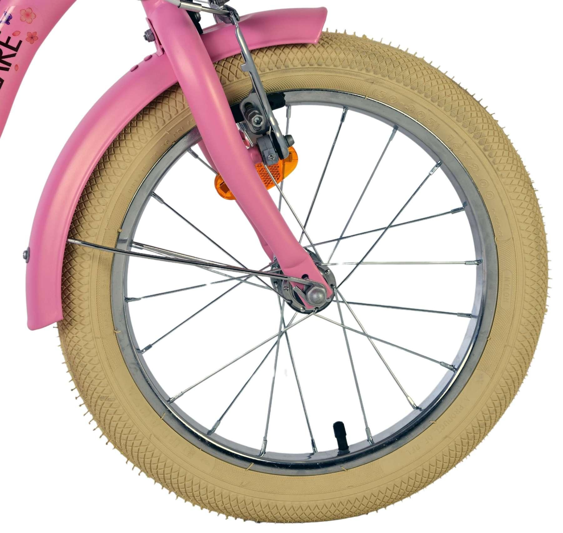 Nahaufnahme eines pinken Fahrradschutzblechs und eines hellbeigen Reifens mit Speichen.