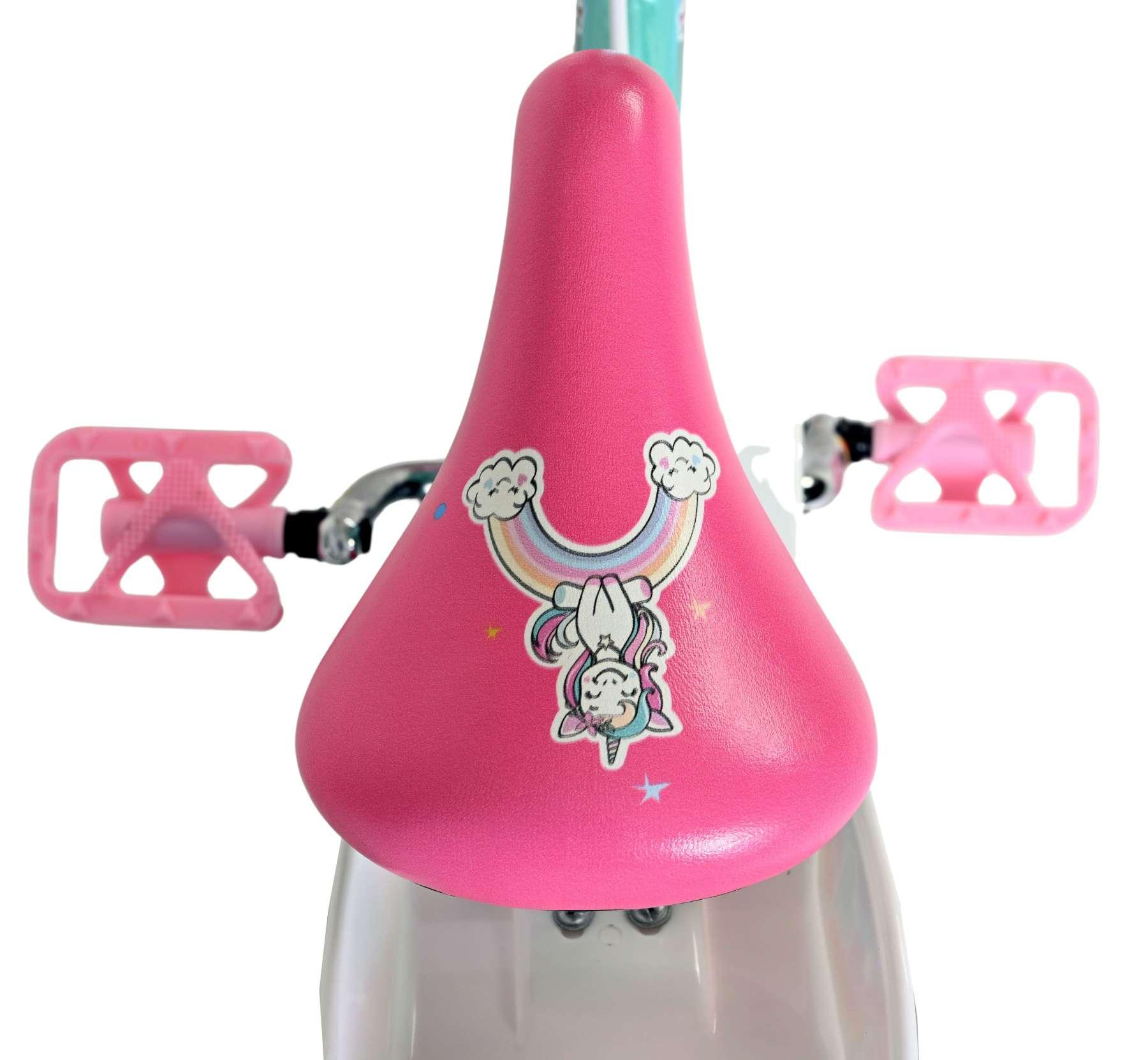Rosa Fahrradsattel mit Einhorn- und Regenbogenaufkleber, pinke Pedale.