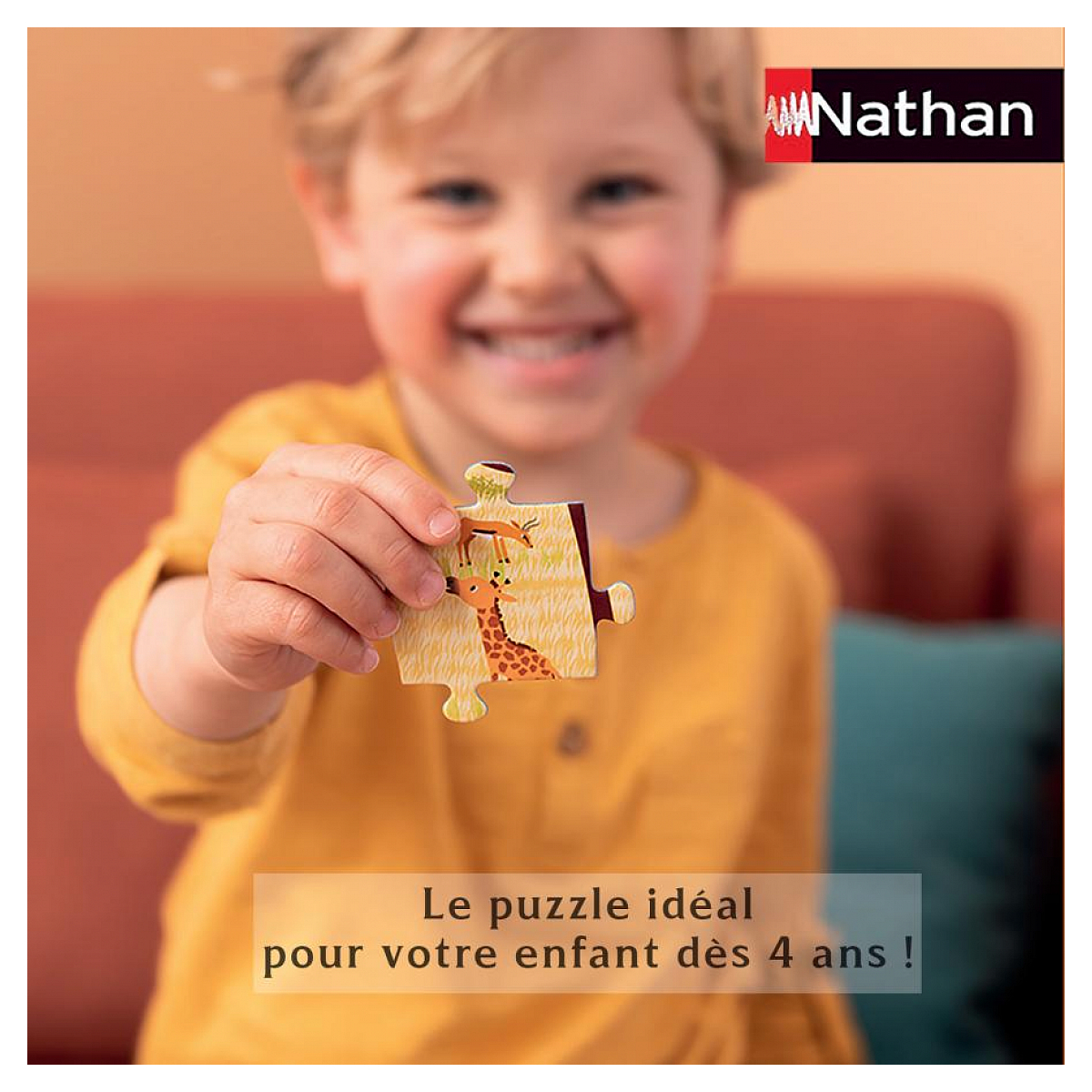 Ein Junge hält ein Puzzle-Teil mit Giraffe und Reh.