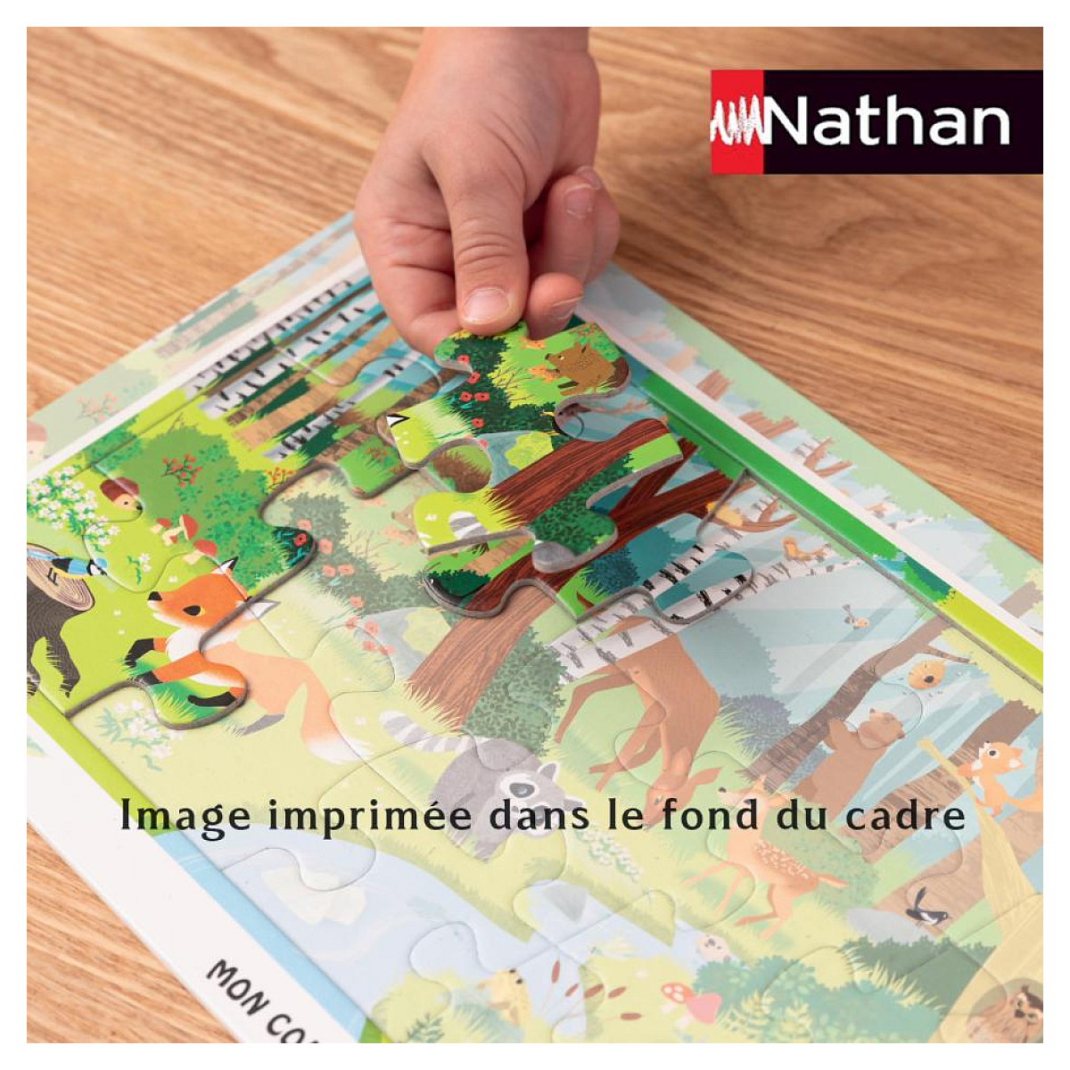 Ein Kind legt ein Puzzleteil mit Waldtieren auf ein angefangenes Puzzle.