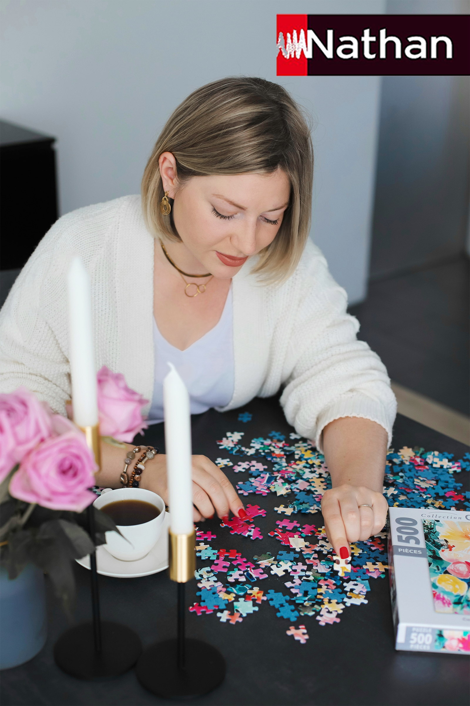Frau löst ein 500-Teile-Puzzle mit Blumenmotiv auf einem schwarzen Tisch.
