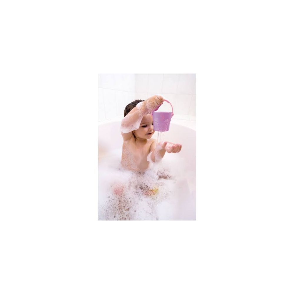 Ein Kind sitzt in der Badewanne und hält einen Eimer mit Wasser.