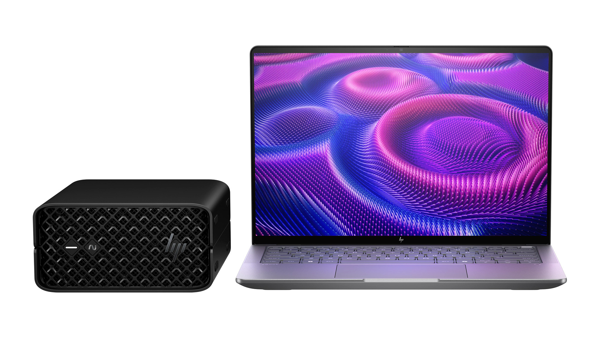 Een zwarte desktop computertoren naast een open zilveren laptop met paars en blauw abstract behang.